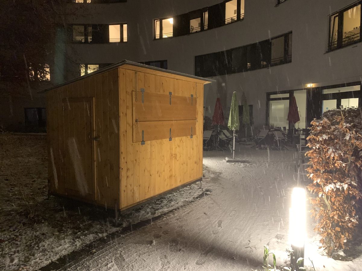 Markthuette klein bei Schneefall am Abend