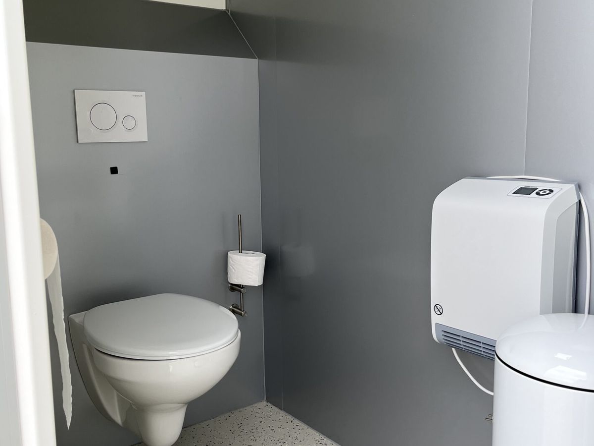 WC-Kabine mit wandhaengendem WC und Handtrockner