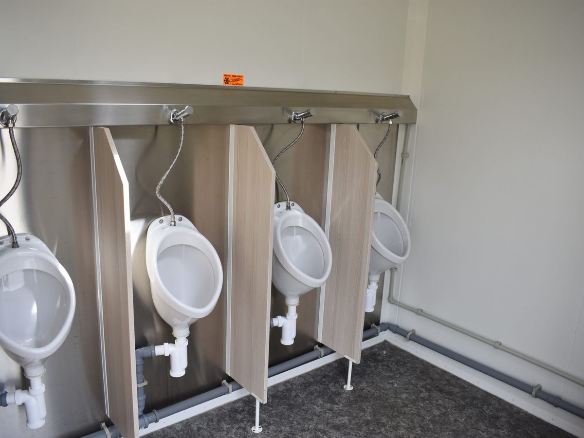 Herrenabteil mit vier Urinalen und Holzoptik-Trennwaenden